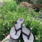 Paire de tongs en cuir MOOREA de couleur taupe posée dans la nature