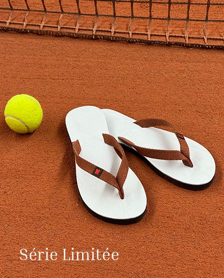 Paire de Tong cuir posée sur un court de tennis en terre battue