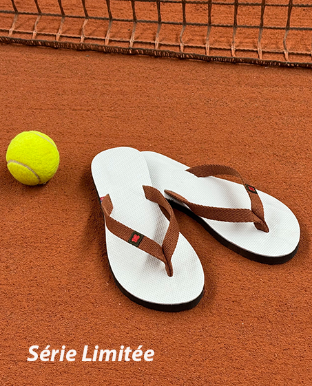 Paire de Tong cuir posée sur un court de tennis en terre battue
